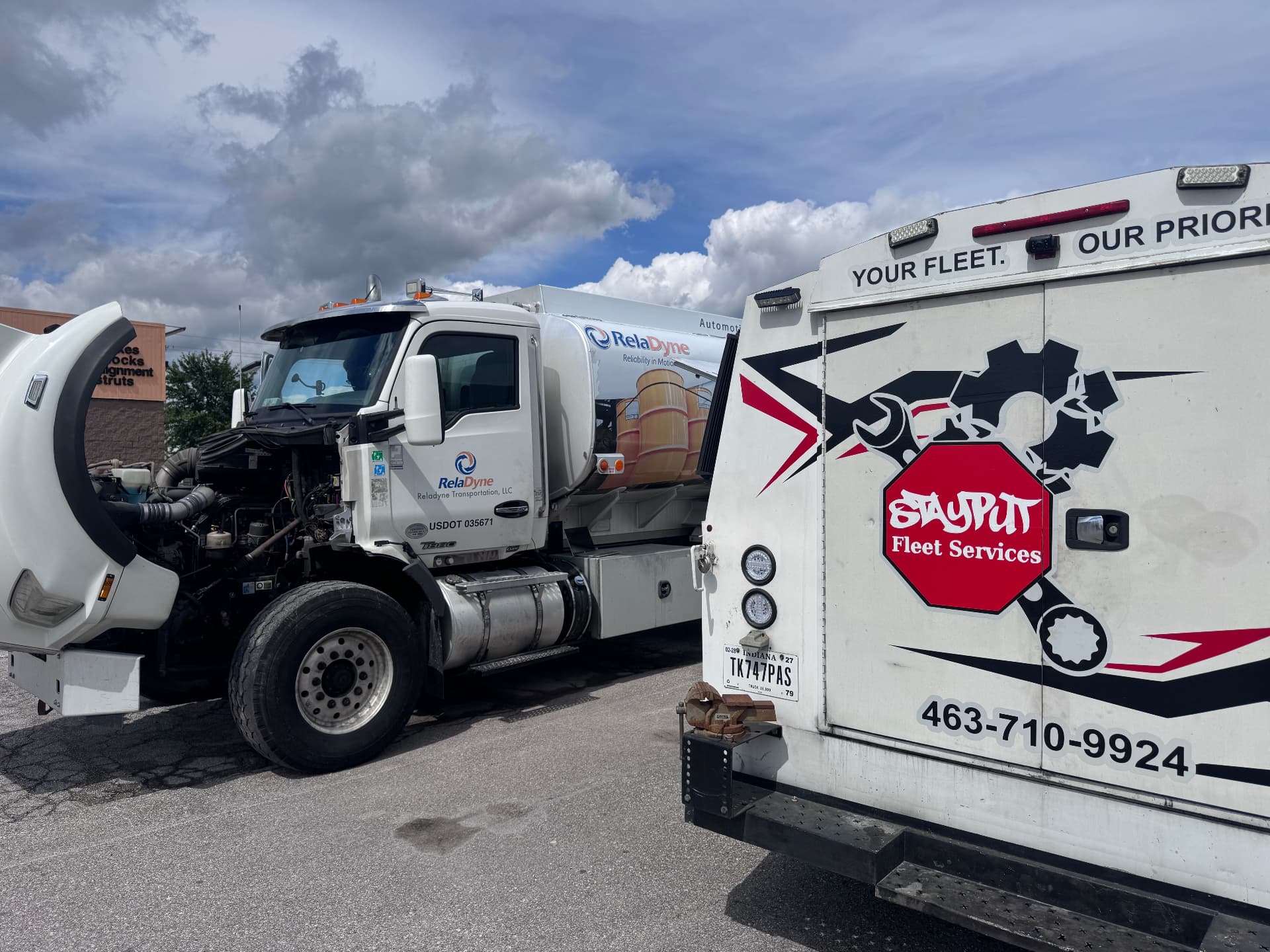 RelaDyne tanker truck with hood open beside StayPut service truck