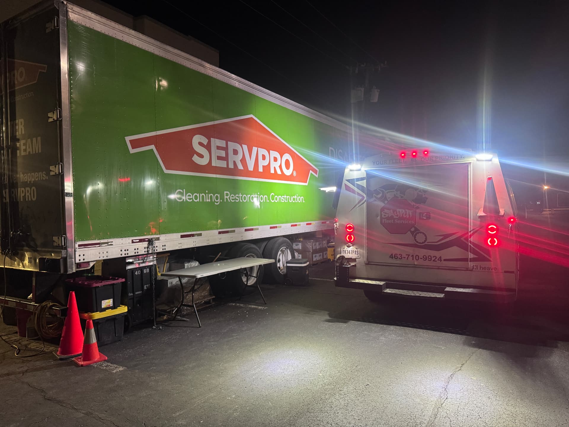 StayPut service truck lit up at night beside a SERVPRO box truck