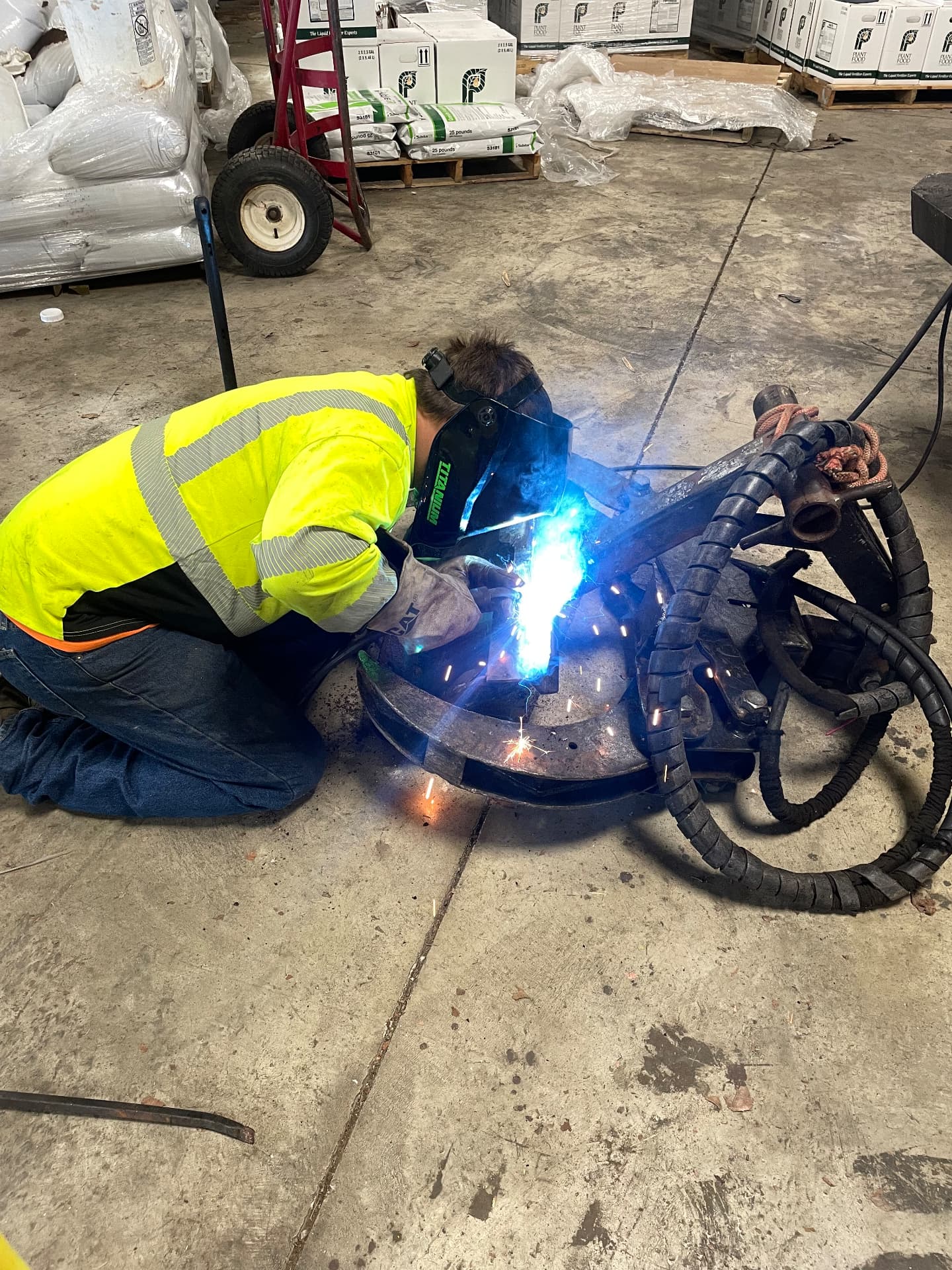 StayPut technician welding a repair on heavy equipment in a customer warehouse